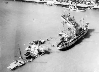 Aerial view of two of the vessels scuttled by the Egyptians in Port Said at the entrance to the Suez Canal in order to prevent any shipping movements. On the right, a British vessel specially equipped for refloating operations.